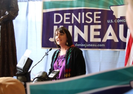 Denise Junear speaking at podum